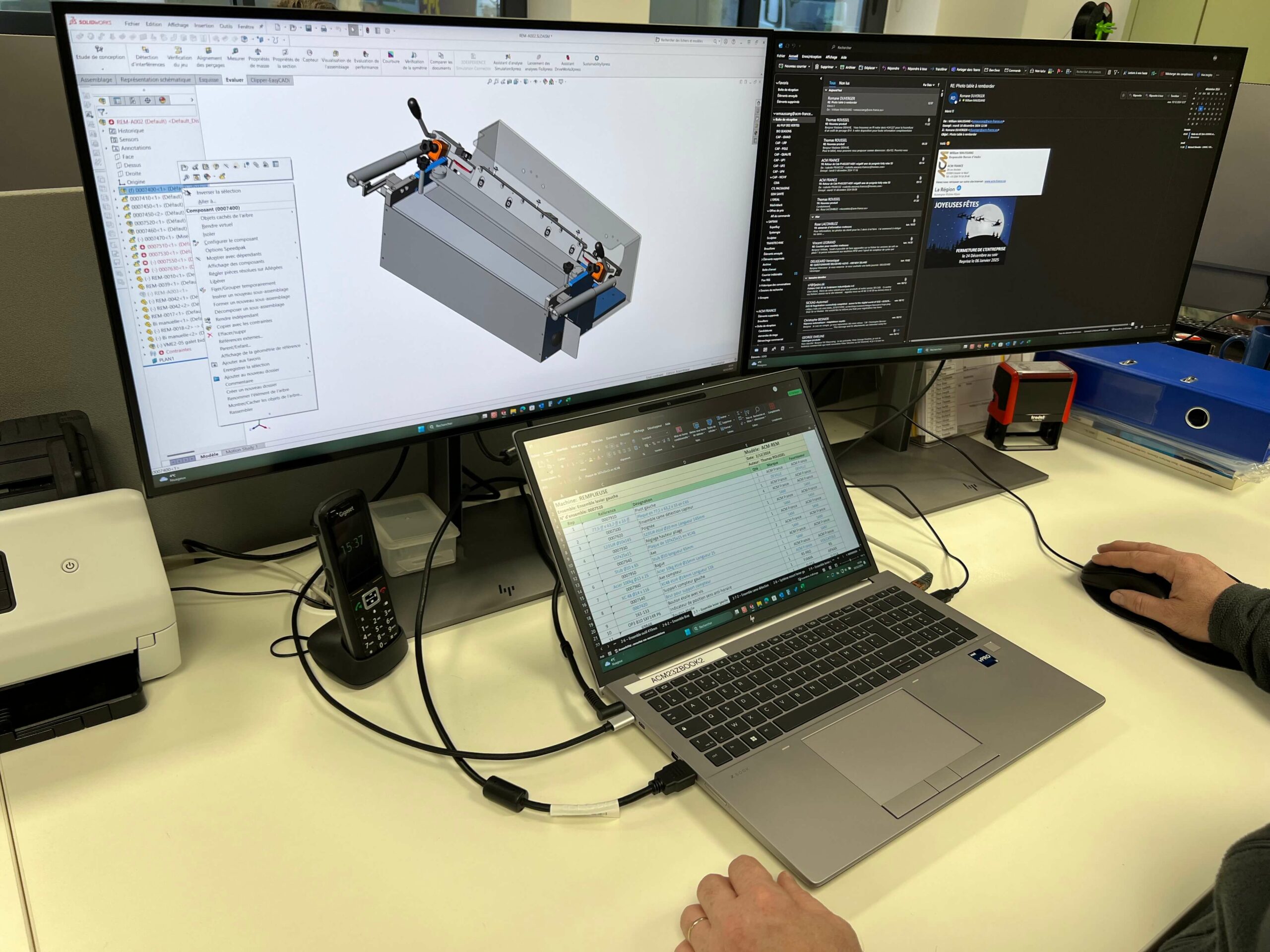 Un poste de travail avec un modèle 3D affiché sur un écran et un tableau Excel ouvert sur un ordinateur portable.